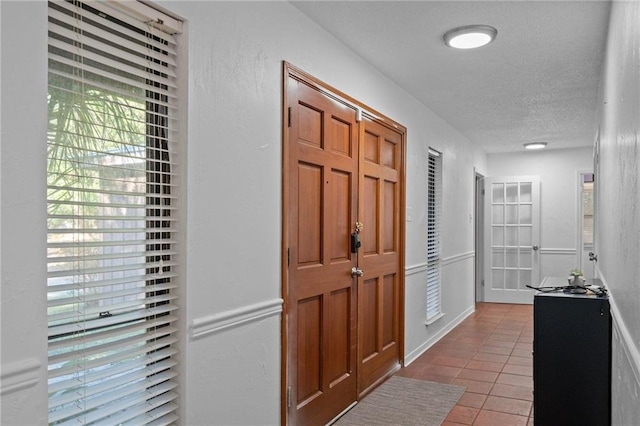 entryway with tile patterned flooring and a textured ceiling
