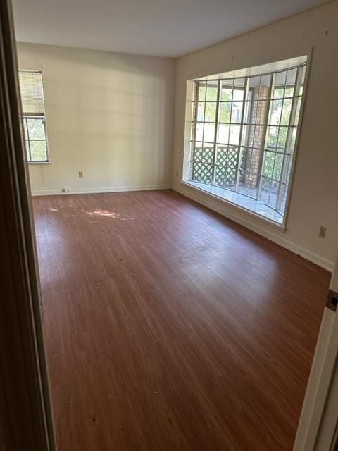 unfurnished room with dark hardwood / wood-style flooring