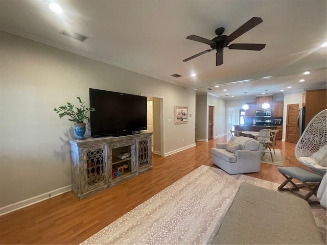 living area with light wood-type flooring, baseboards, visible vents, and recessed lighting