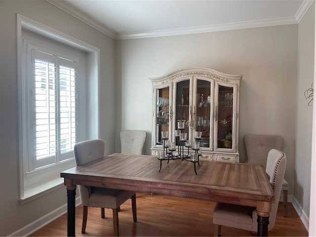 dining room with ornamental molding, wood finished floors, and baseboards