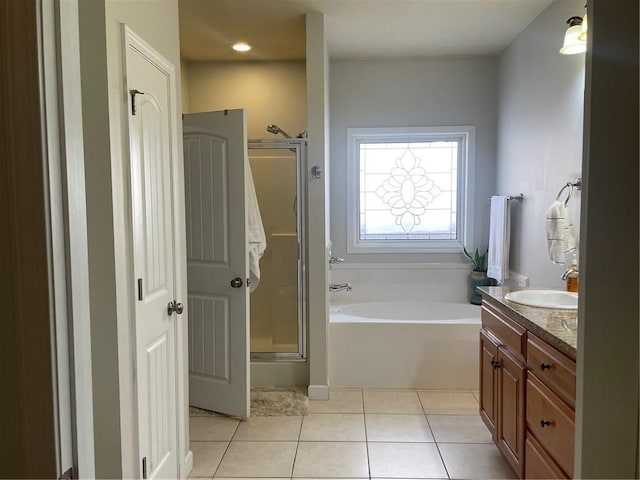 bathroom featuring a stall shower, a garden tub, vanity, and tile patterned floors