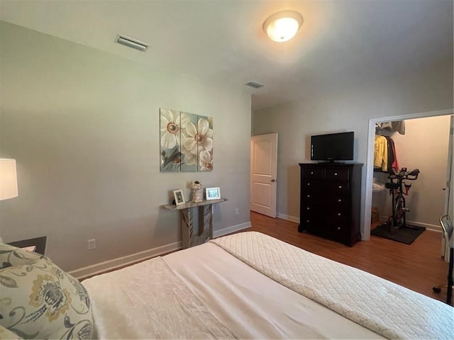 bedroom featuring baseboards, visible vents, and wood finished floors