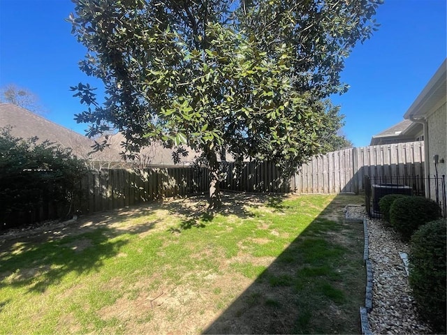 view of yard featuring central AC and a fenced backyard