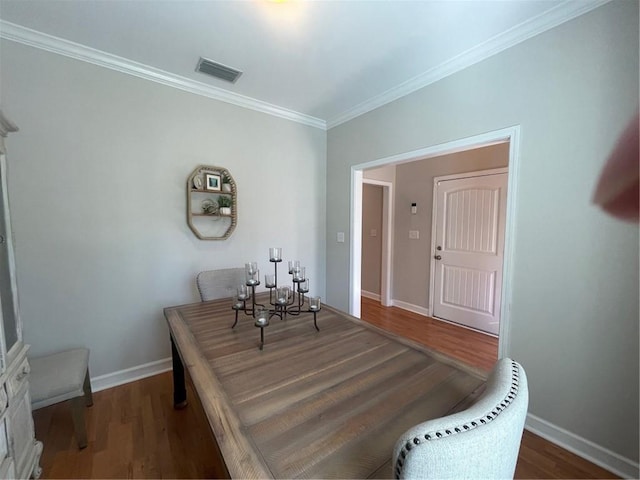 dining area featuring baseboards, visible vents, wood finished floors, and ornamental molding