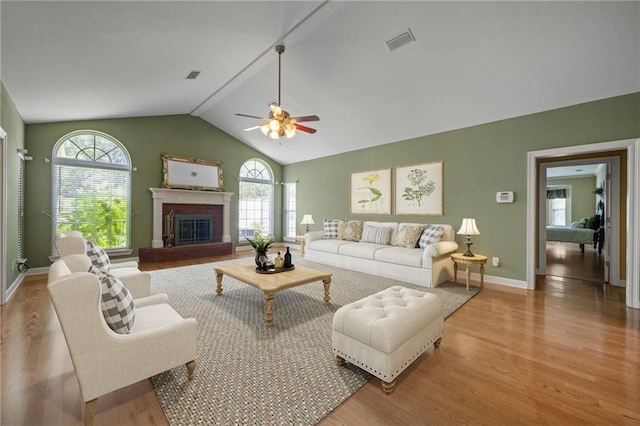 living room with plenty of natural light, lofted ceiling, and light wood-type flooring