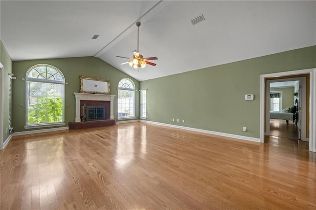 unfurnished living room featuring ceiling fan, lofted ceiling, light hardwood / wood-style flooring, and a wealth of natural light