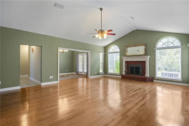 unfurnished living room with light hardwood / wood-style flooring, a fireplace, ceiling fan, and vaulted ceiling