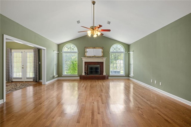 unfurnished living room with light hardwood / wood-style flooring, a fireplace, lofted ceiling, and plenty of natural light