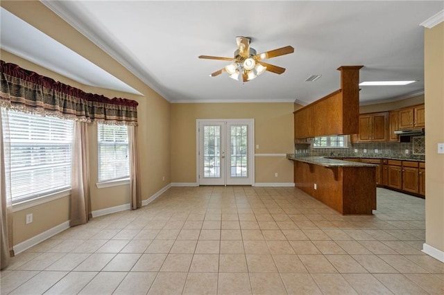 kitchen featuring a kitchen bar, decorative backsplash, light tile patterned floors, kitchen peninsula, and french doors