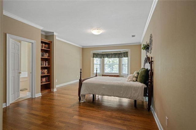 bedroom featuring hardwood / wood-style flooring, ensuite bath, and crown molding