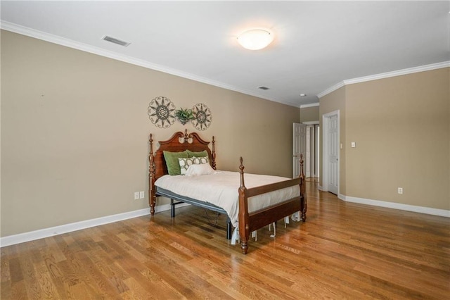 bedroom featuring ornamental molding and light hardwood / wood-style floors