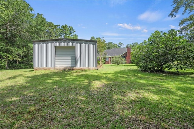 view of yard featuring a garage and an outbuilding