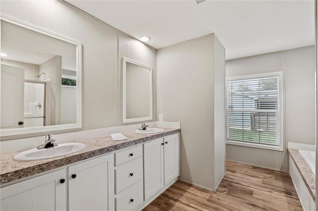 bathroom featuring vanity, separate shower and tub, and hardwood / wood-style floors