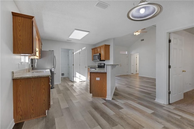 kitchen featuring ceiling fan, sink, light hardwood / wood-style flooring, and appliances with stainless steel finishes