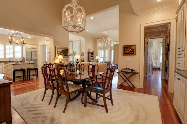 dining space with light hardwood / wood-style floors, crown molding, and sink