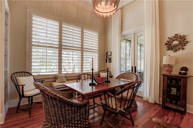 dining area featuring french doors, a notable chandelier, crown molding, and hardwood / wood-style floors