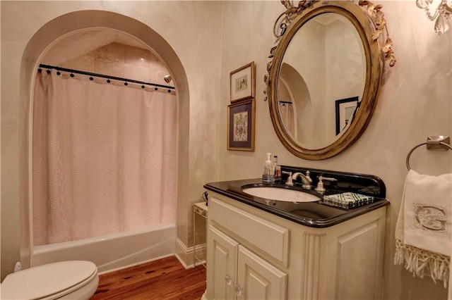 full bathroom featuring vanity, shower / bath combination with curtain, hardwood / wood-style flooring, and toilet