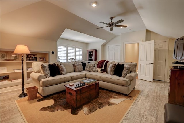 living room with ceiling fan, vaulted ceiling, and light hardwood / wood-style flooring