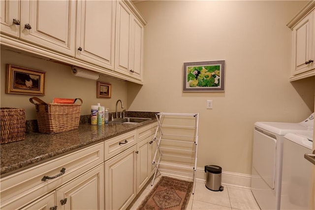 washroom featuring light tile patterned floors, cabinets, sink, and washer and dryer