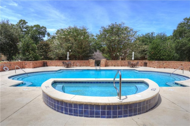 view of swimming pool featuring a community hot tub