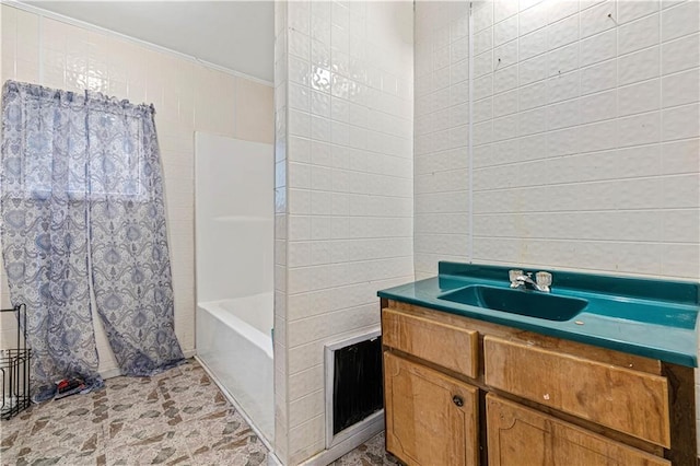 bathroom with vanity, tile walls, and shower / bath combo with shower curtain