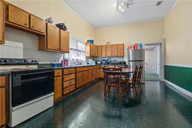 kitchen featuring range with electric stovetop, stainless steel refrigerator, sink, decorative backsplash, and crown molding