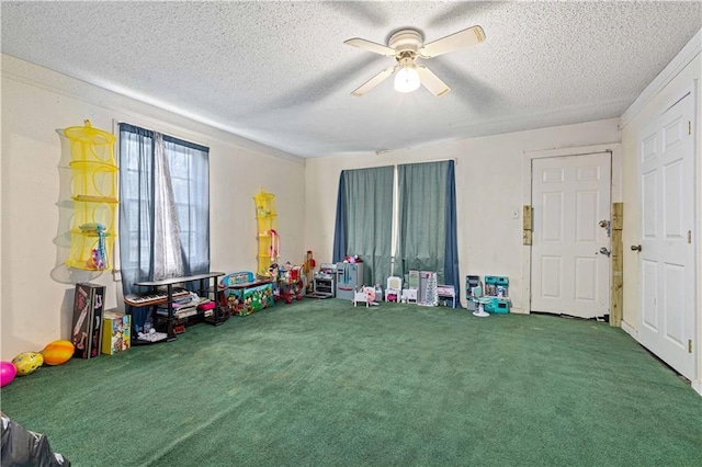 game room with ceiling fan, carpet floors, and a textured ceiling