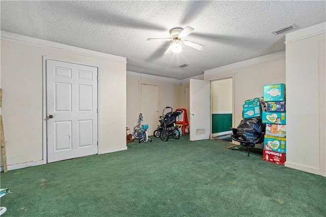 game room featuring ceiling fan, crown molding, a textured ceiling, and carpet flooring