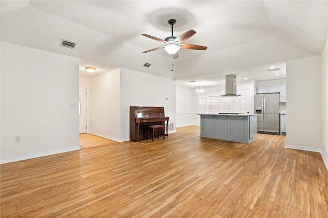 kitchen featuring light wood-style flooring, stainless steel fridge, visible vents, and extractor fan