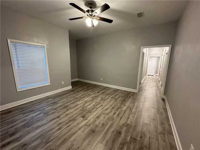 unfurnished room featuring dark wood-type flooring and ceiling fan