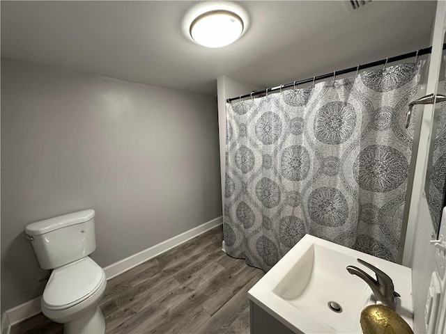 bathroom with hardwood / wood-style flooring, toilet, sink, and a shower with shower curtain