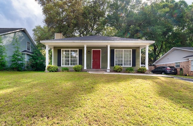 view of front of home with a porch, a front lawn, and a chimney