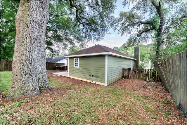 rear view of house featuring a chimney and a fenced backyard