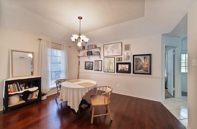 dining room with an inviting chandelier, baseboards, and wood finished floors