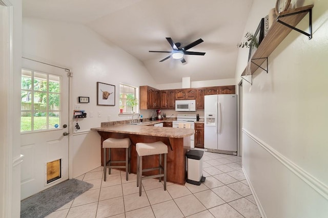 kitchen with white appliances, ceiling fan, light tile patterned flooring, a peninsula, and vaulted ceiling