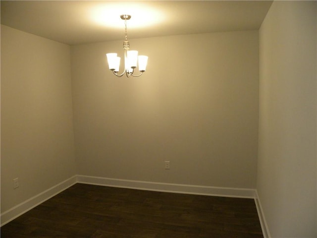 unfurnished room with a chandelier and dark hardwood / wood-style flooring