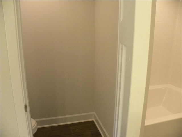 bathroom featuring hardwood / wood-style floors, toilet, and tub / shower combination