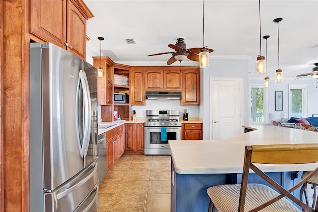 kitchen featuring a kitchen breakfast bar, stainless steel appliances, ceiling fan, crown molding, and pendant lighting