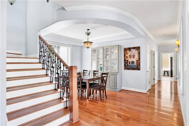 dining space featuring light hardwood / wood-style floors, an inviting chandelier, and crown molding