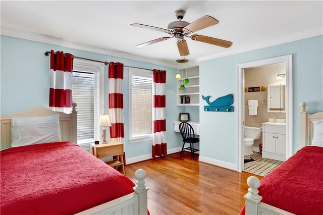 bedroom with light wood-type flooring, ensuite bathroom, ceiling fan, and crown molding