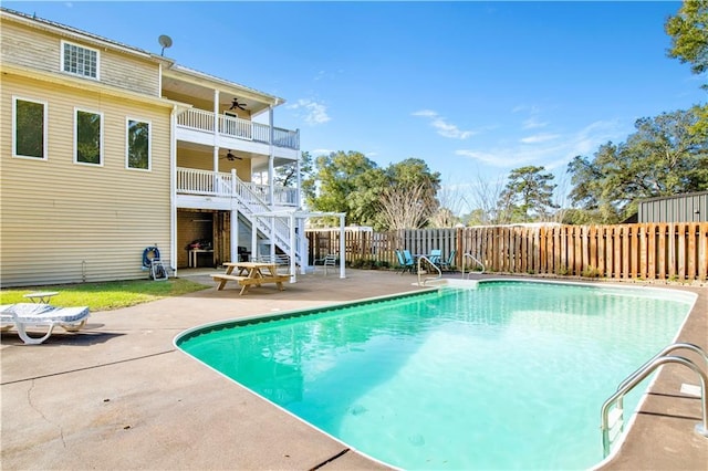 view of swimming pool with ceiling fan and a patio