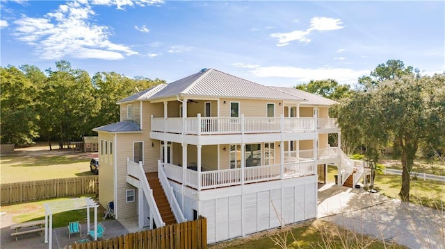 rear view of house featuring a garage, a balcony, and a patio