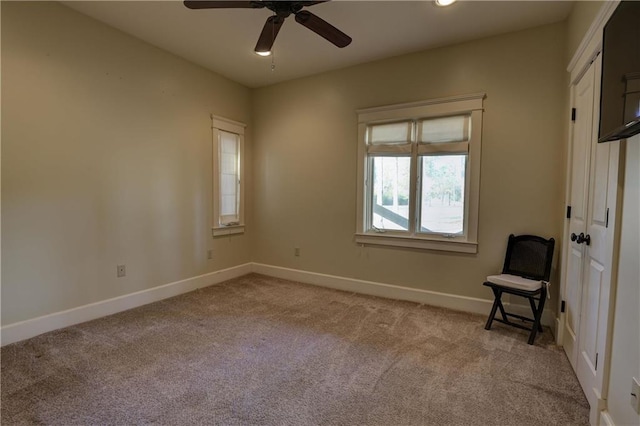 carpeted spare room with ceiling fan