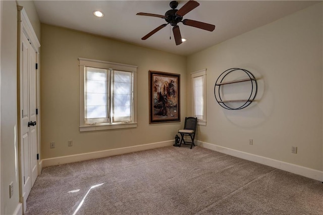 carpeted spare room with ceiling fan