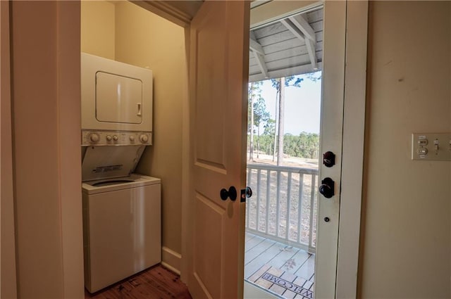 laundry room featuring hardwood / wood-style floors and stacked washer / dryer