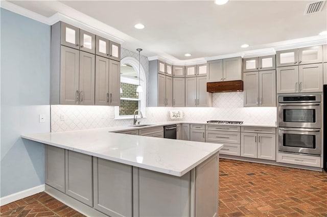 5555 Briarfield Ln, Mobile, AL 36693 - kitchen with appliances with stainless steel finishes, brick flooring, a peninsula, recessed lighting, and decorative backsplash