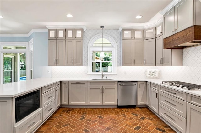 5555 Briarfield Ln, Mobile, AL 36693 - kitchen featuring appliances with stainless steel finishes, a peninsula, crown molding, light countertops, and brick flooring
