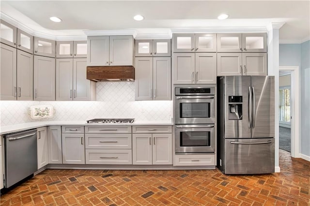 5555 Briarfield Ln, Mobile, AL 36693 - kitchen featuring appliances with stainless steel finishes, crown molding, brick floors, light countertops, and decorative backsplash