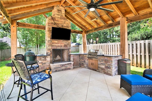 5555 Briarfield Ln, Mobile, AL 36693 - fenced backyard featuring exterior kitchen, an outdoor stone fireplace, a patio, and ceiling fan