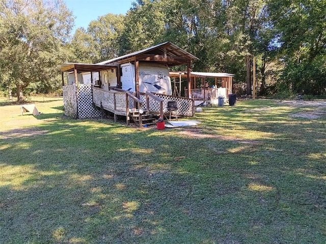 back of property with a wooden deck and a yard